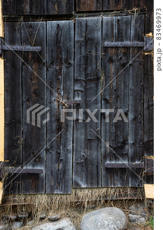 Wooden rustic barn door, faded and vintage tones, wooden board texture Wooden rustic barn door, faded and vintage tones, wooden board texture 83469973