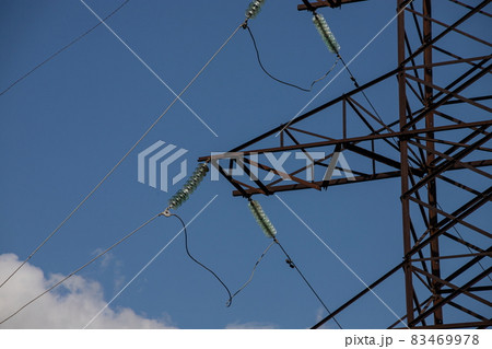 Power lines on background of blue sky close-up. Electric hub on pole. Electricity equipment with copy space. Wires of high voltage in sky Power lines on background of blue sky close-up. Electric hub on pole. Electricity equipment with copy space. Wires of high voltage in sky 83469978