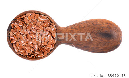 Brown flax seeds in wooden spoon, isolated on white background. Heap of dry flaxseed or linseed. Top view. Brown flax seeds in wooden spoon, isolated on white background. Heap of dry flaxseed or linseed. Top view. 83470153