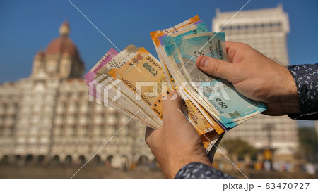 A man considers Indian rupees on the street of Mumbai. Hands close up. A man considers Indian rupees on the street of Mumbai. Hands close up. 83470727
