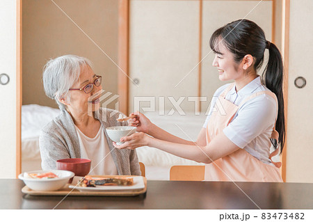 食事をする高齢者女性と女性スタッフ(食事介助) 食事をする高齢者女性と女性スタッフ(食事介助) 83473482