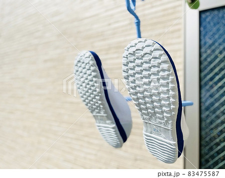 洗った後にハンガーで干している上履き 83475587