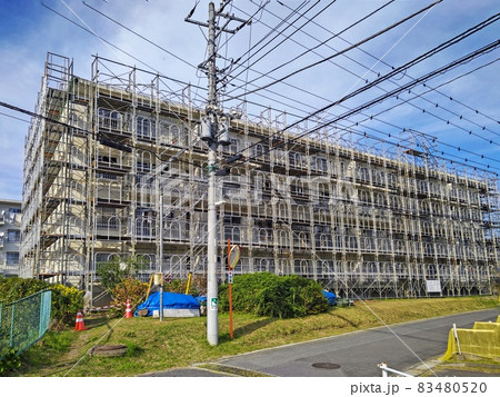 足場で覆われた修繕工事中の古い4階建てのアパート 足場で覆われた修繕工事中の古い4階建てのアパート 83480520