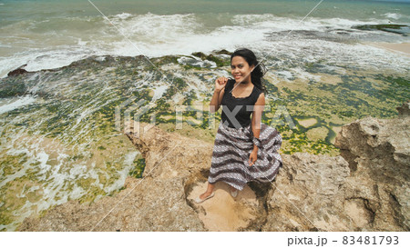 Indonesian girl posing on a beautiful and rocky beach in Bali. Idonezia. Indonesian girl posing on a beautiful and rocky beach in Bali. Idonezia. 83481793