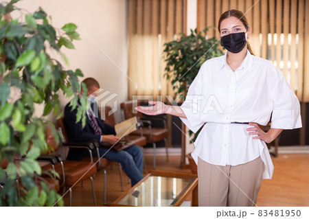 Portrait of a young confident girl in a protective mask standing in the lobby 83481950