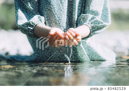 川から水をすくうワンピースを着た女性の手元の写真素材 4529
