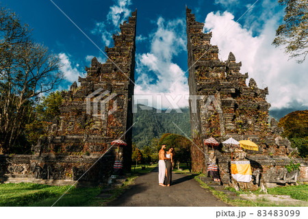 Beautiful couple at the Bali temple. Man and woman traveling in Indonesia. Couple at the Bali gate. The couple travels the world. Travel to tourist places in Asia. Tourists in Bali. Copy space. 83483099
