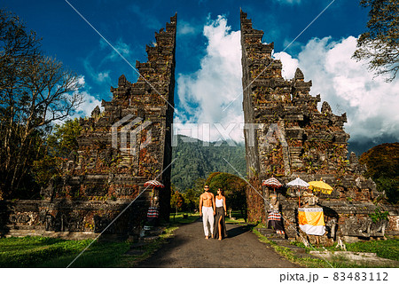 Beautiful couple at the Bali temple. Man and woman traveling in Indonesia. Couple at the Bali gate. The couple travels the world. Travel to tourist places in Asia. Tourists in Bali. Copy space. 83483112