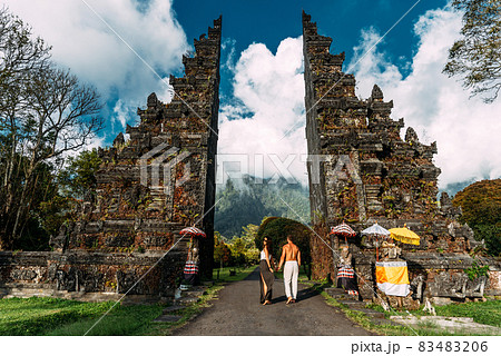 Beautiful couple at the Bali temple. Man and woman traveling in Indonesia. Couple at the Bali gate. The couple travels the world. Travel to tourist places in Asia. Tourists in Bali. Copy space. 83483206