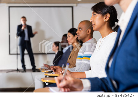 Confident woman listening to lecture at conference Confident woman listening to lecture at conference 83485427