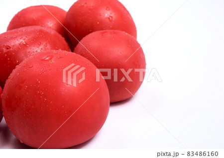 Red tomatoes on a white background. Free space for text. Water drops on wet vegetables. 83486160