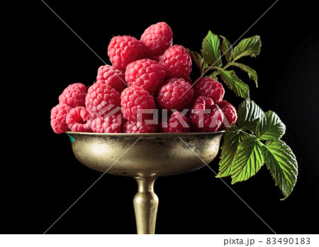 Fresh raspberries with leaves in an old brass dish. Fresh raspberries with leaves in an old brass dish. 83490183