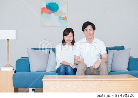 リビングで寛ぐ若い新婚の夫婦 リビングで寛ぐ若い新婚の夫婦 83490226
