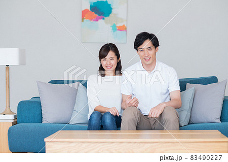 リビングで寛ぐ若い新婚の夫婦 リビングで寛ぐ若い新婚の夫婦 83490227