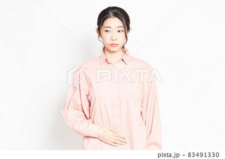 お腹を手で抑えている女性 83491330