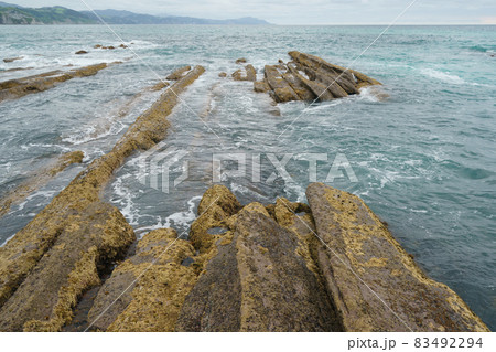 Atlantic ocean coast at low tide in Bay of Biscay. Charming Zumaia Itzurun beach. K-T boundary. Mid-cretaceous period. For greeting card design, postcard template, touristic guide, magazine, poster. Atlantic ocean coast at low tide in Bay of Biscay. Charming Zumaia Itzurun beach. K-T boundary. Mid-cretaceous period. For greeting card design, postcard template, touristic guide, magazine, poster. 83492294
