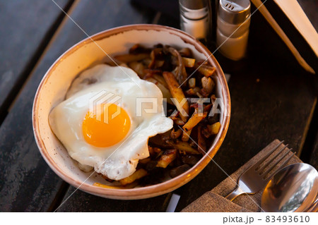 Fried egg with baked potatoes with eggplant and pepper Fried egg with baked potatoes with eggplant and pepper 83493610