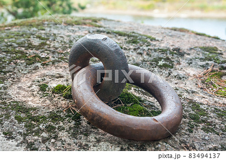 Closeup of a rusty old mooring loop fastened in a rock, used to tie up boats in the river Closeup of a rusty old mooring loop fastened in a rock, used to tie up boats in the river 83494137