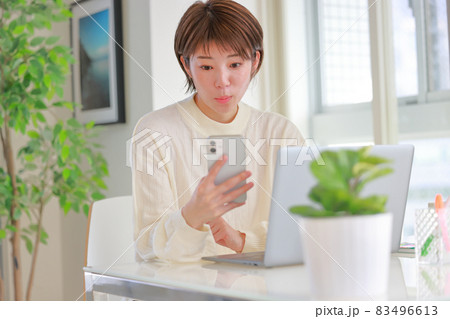スマホを見てニュース記事に注目する女性 スマホを見てニュース記事に注目する女性 83496613
