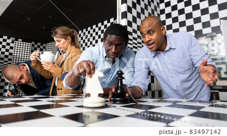 Group of friends solving puzzle together in quest room stylized chessboard 83497142