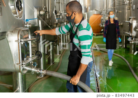 Male worker in mask working at winery 83497443