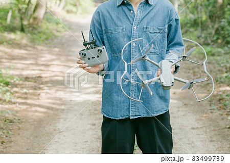 ドローンを持つ男性 ドローンを手に持って立つ人 ドローンを持つ男性 ドローンを手に持って立つ人 83499739