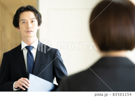 廊下ですれ違うスーツ姿の男女 83501154