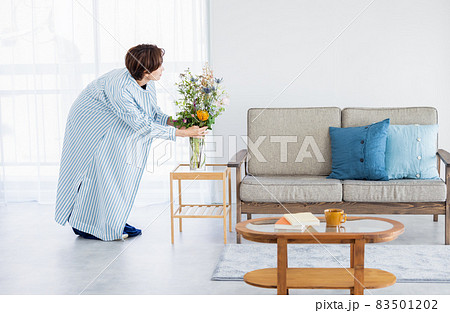 リビングに花を飾る女性 83501202