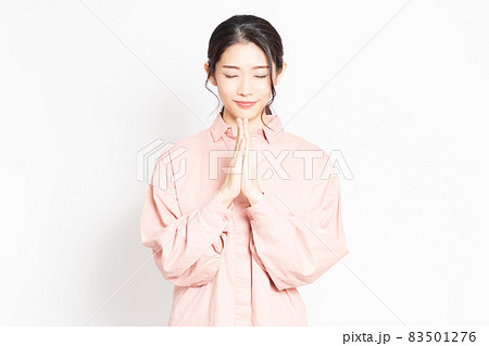 手を合わせてお願いする女性 83501276