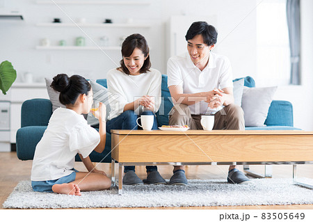 リビングでくつろぐ若い家族 83505649