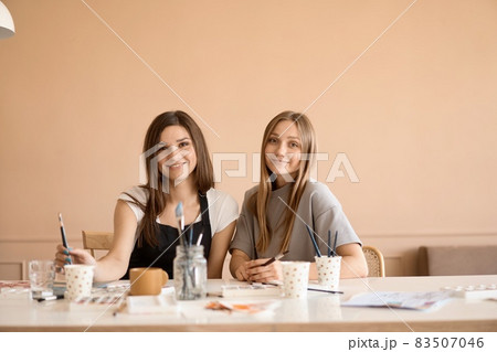 Front view of four beautiful caucasian female at art workshop. A young teacher teaches drawing 83507046