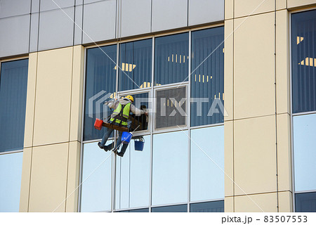 Man Cleaning windows on a Office Building Man Cleaning windows on a Office Building 83507553