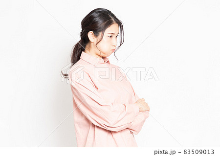 白背景の前で怒っているポーズをする女性 83509013