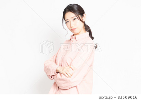 白背景の前で怒っているポーズをする女性 83509016