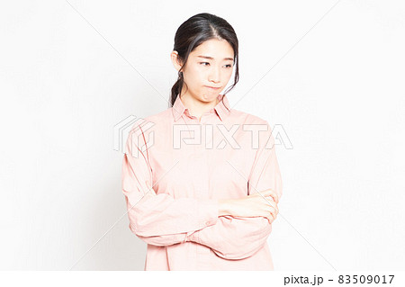 白背景の前で怒っているポーズをする女性 83509017