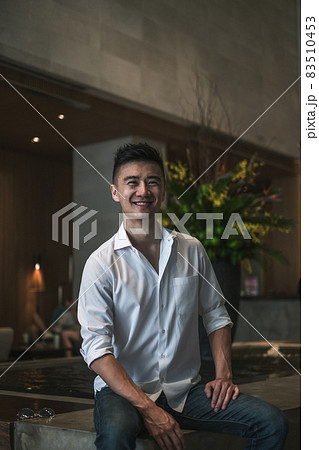 Asian young handsome man standing in coffee shop and smiling. Chinese guy, millennials life, lifestyle in the big city, Modern Asia, coffee break Asian young handsome man standing in coffee shop and smiling. Chinese guy, millennials life, lifestyle in the big city, Modern Asia, coffee break 83510453