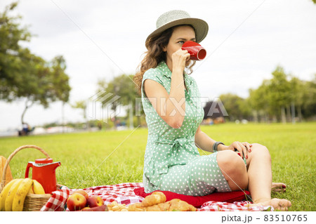 Beautiful young woman having picnic. 83510765