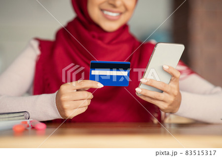 Unrecognizable muslim lady using mobile phone and credit card 83515317