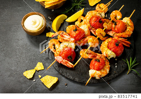 Delicious Grilled shrimps with spice, lemon and sauce served on a slate board served with nachos chips. Seafood. Top view flat lay background. Free space for your text. 83517741