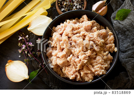 Minced meat, pasta and ingredients for cooking minced meat in a bowl on a slate. 83518869