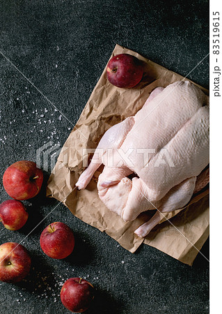 Raw uncooked whole duck on paper over black background Raw uncooked whole duck on paper over black background 83519615