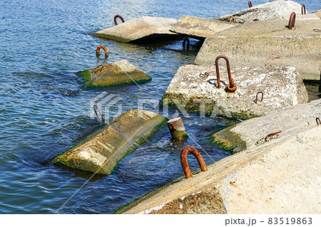 port breakwater concrete blocks in the water with metal hooks 83519863