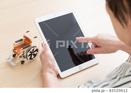 タブレットを操作するシニア 83520012
