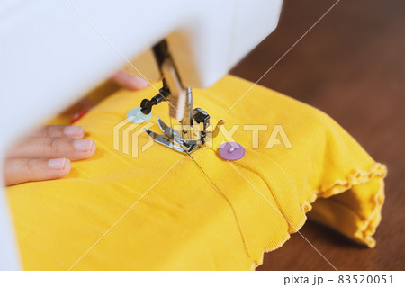 A young woman is sewing using a sewing machine. A young woman is sewing using a sewing machine. 83520051