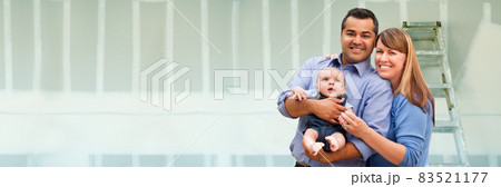 Young Biracial Family Inside Room with New Sheetrock Drywall and Ladder. Young Biracial Family Inside Room with New Sheetrock Drywall and Ladder. 83521177