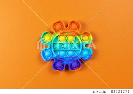 Anti-stress toy pop it, simple dimple, on orange background, copy space. Concept trendy entertainment for fidget children, sensory toys for development of fine motor skills, stress relieving 83521271