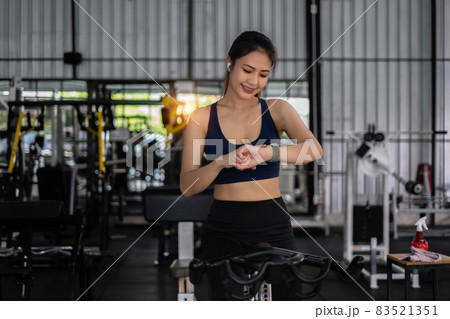 Beautiful sporty woman using smart watch checking notify between sports training at gym 83521351