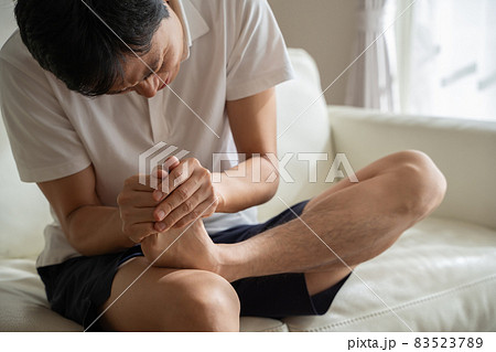 つま先を痛がる男性の様子 83523789
