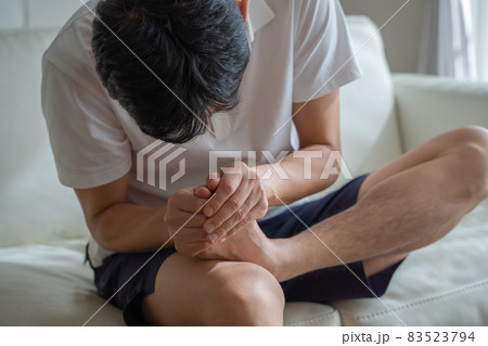 つま先を痛がる男性の様子 83523794