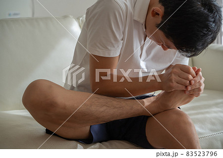 つま先を痛がる男性の様子 83523796